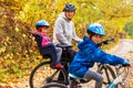 Family cycling in golden autumn park, active father and kids ride bikes, family sport and fitness with children Royalty Free Stock Photo