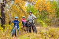 Family cycling in golden autumn park, active father and kids ride bikes, family sport and fitness with children Royalty Free Stock Photo