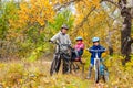 Family cycling in golden autumn park, active father and kids ride bikes, family sport and fitness with children Royalty Free Stock Photo