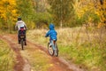 Family cycling in golden autumn park, active father and kids ride bikes, family sport and fitness with children Royalty Free Stock Photo