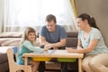 Family Dad, Mom and Little Daughter playing  board game together at home. Royalty Free Stock Photo