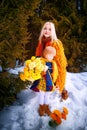 Family with daughter and mother in orange dress with yellow flowers having fun and joy in woods, forest or park with Royalty Free Stock Photo