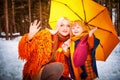 Family with daughter and mother in orange dress with yellow umbrella having fun and joy in woods, forest or park with Royalty Free Stock Photo