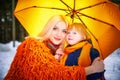 Family with daughter and mother in orange dress with yellow umbrella having fun and joy in woods, forest or park with Royalty Free Stock Photo