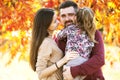 Family with daughter walks in autumn park