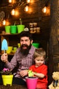 Family day. Greenhouse. Flower care watering. Soil fertilizers. bearded man and little boy child love nature. happy Royalty Free Stock Photo