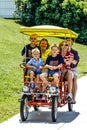 Family riding a four-wheel peddle bike