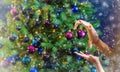 A family decorates a Christmas tree at night. Selective focus Royalty Free Stock Photo