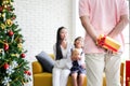 Family decorating a Christmas tree and Father giving Christmas G Royalty Free Stock Photo