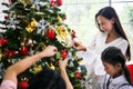 Family decorating a Christmas tree and Father giving Christmas G Royalty Free Stock Photo