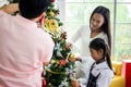 Family decorating a Christmas tree and Father giving Christmas G Royalty Free Stock Photo