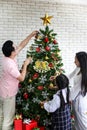 Family decorating a Christmas tree and Father giving Christmas G Royalty Free Stock Photo