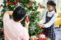 Family decorating a Christmas tree and Father giving Christmas G Royalty Free Stock Photo