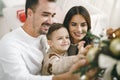 Family of 3 decorating a Christmas tree at home Royalty Free Stock Photo
