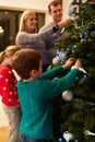 Family Decorating Christmas Tree At Home Together Royalty Free Stock Photo