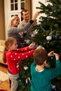Family Decorating Christmas Tree At Home Together Royalty Free Stock Photo
