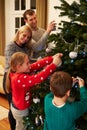 Family Decorating Christmas Tree At Home Together