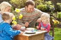 Family Decorating Easter Eggs On Table Outdoors