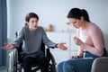 Family disagreement. Upset mother crying and her teenage son in wheelchair trying to justify himself at home Royalty Free Stock Photo