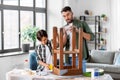 father and son with ruler measuring old table