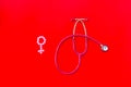 Diagnostic and cure of gynaecological disease with stethoscope and female symbol on red background top view