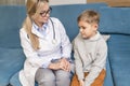 A family doctor examines a little boy at home. Pediatrician girl treats a child