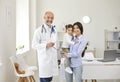 Family doctor. Mother and little girl patients visit to senior doctor at clinic office. Royalty Free Stock Photo