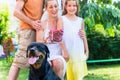 Family with dog harvesting cherries in garden Royalty Free Stock Photo