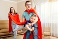 A family dressed in superhero costumes plays the room Royalty Free Stock Photo
