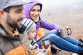 Family drinking tea from metal cups