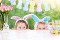 Kids with bunny ears and eggs on Easter egg hunt. Royalty Free Stock Photo