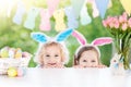 Kids with bunny ears and eggs on Easter egg hunt. Royalty Free Stock Photo