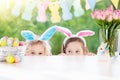 Kids with bunny ears and eggs on Easter egg hunt. Royalty Free Stock Photo