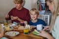Family eating breakfast together in home kitchen. Healthy breakfast or snack before school and work. Royalty Free Stock Photo