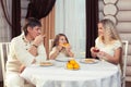 Family eating dinner at a dining table, Round table, pizza, orange, house made of wood Royalty Free Stock Photo