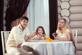 Family eating dinner at a dining table, Round table, pizza, orange, house made of wood Royalty Free Stock Photo