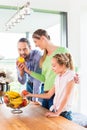 Family eating fresh fruits for healthy living in kitchen Royalty Free Stock Photo