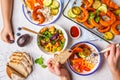 Family eating a healthy vegetarian food. Vegan lunch table top view, plant based diet. Baked vegetables, fresh salad, berries, Royalty Free Stock Photo