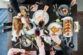 Family eating for holiday table at home. Easter holidays table with baked meat tenderloin, rib eye meat, ribs, lamb thigh, wine Royalty Free Stock Photo