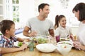 Family Eating Meal Around Kitchen Table Together