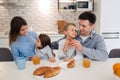 Family, eating and people concept - happy mother, father,daughter and son having breakfast at home on modern kitchen Royalty Free Stock Photo