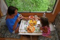 Family eating together in motorhome camper, caravan on vacation