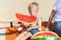 Family is eating a watermelon together on the sandy beach. Royalty Free Stock Photo