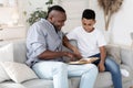 Family Education. Black Grandfather Reading Book With His Preteen Grandson At Home Royalty Free Stock Photo