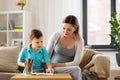 Pregnant mother and son with workbook at home