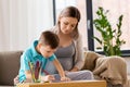 Pregnant mother and son with workbook at home