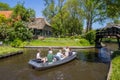 Family in an electric motorboat enjoying their vacation in Giethoorn