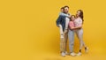 Family embraced and smiling on yellow background Royalty Free Stock Photo
