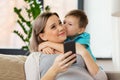 Son kissing happy pregnant mother at home Royalty Free Stock Photo