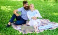 Family enjoy relax nature background. Couple bearded man and blonde woman relax nature while sit on green grass meadow Royalty Free Stock Photo